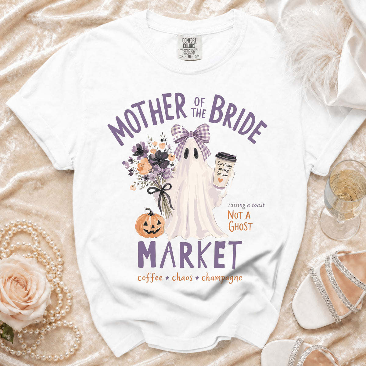 White t-shirt with "Mother of the Bride Market" graphic featuring a ghost, pumpkin, and flowers.