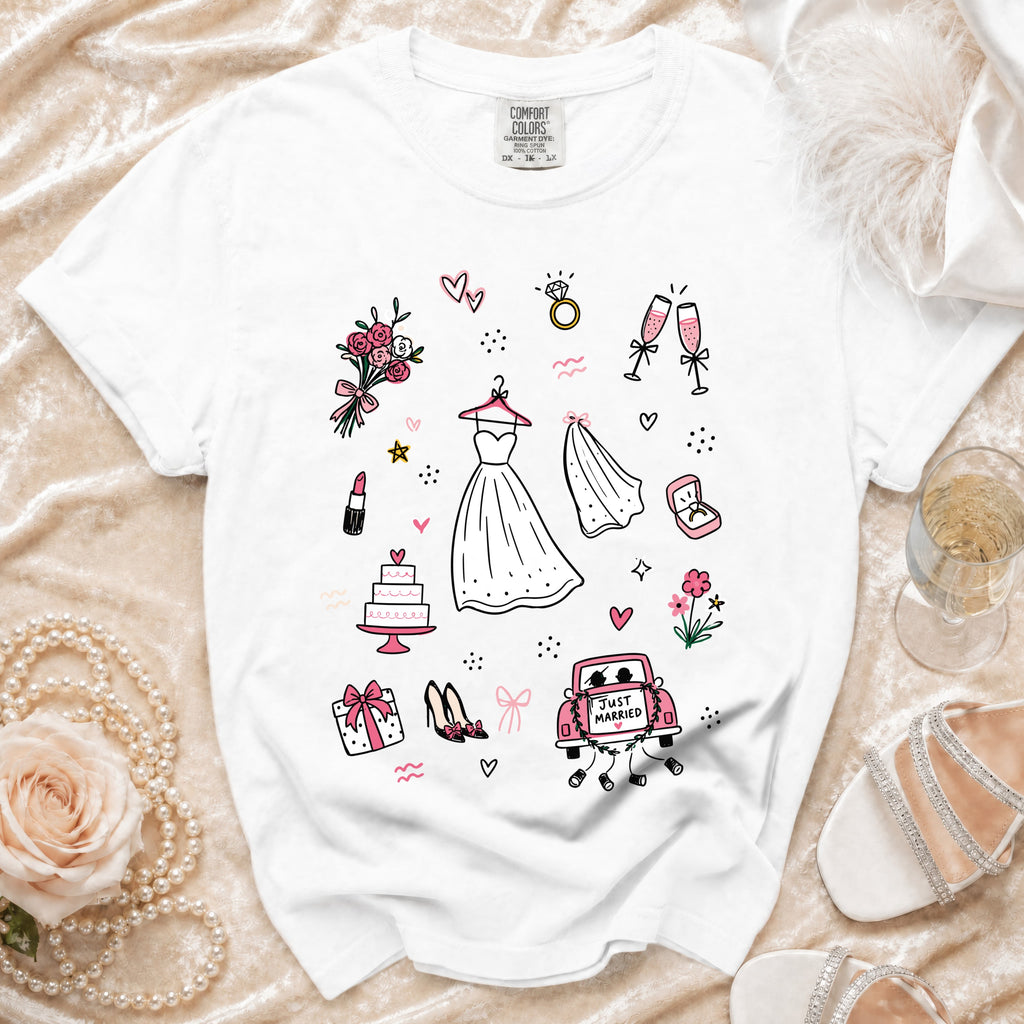 White t-shirt with wedding-themed illustrations including a dress, cake, and "Just Married" car.