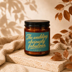 Amber candle with teal label saying "The wedding, obviously fabulous" and "vowed".