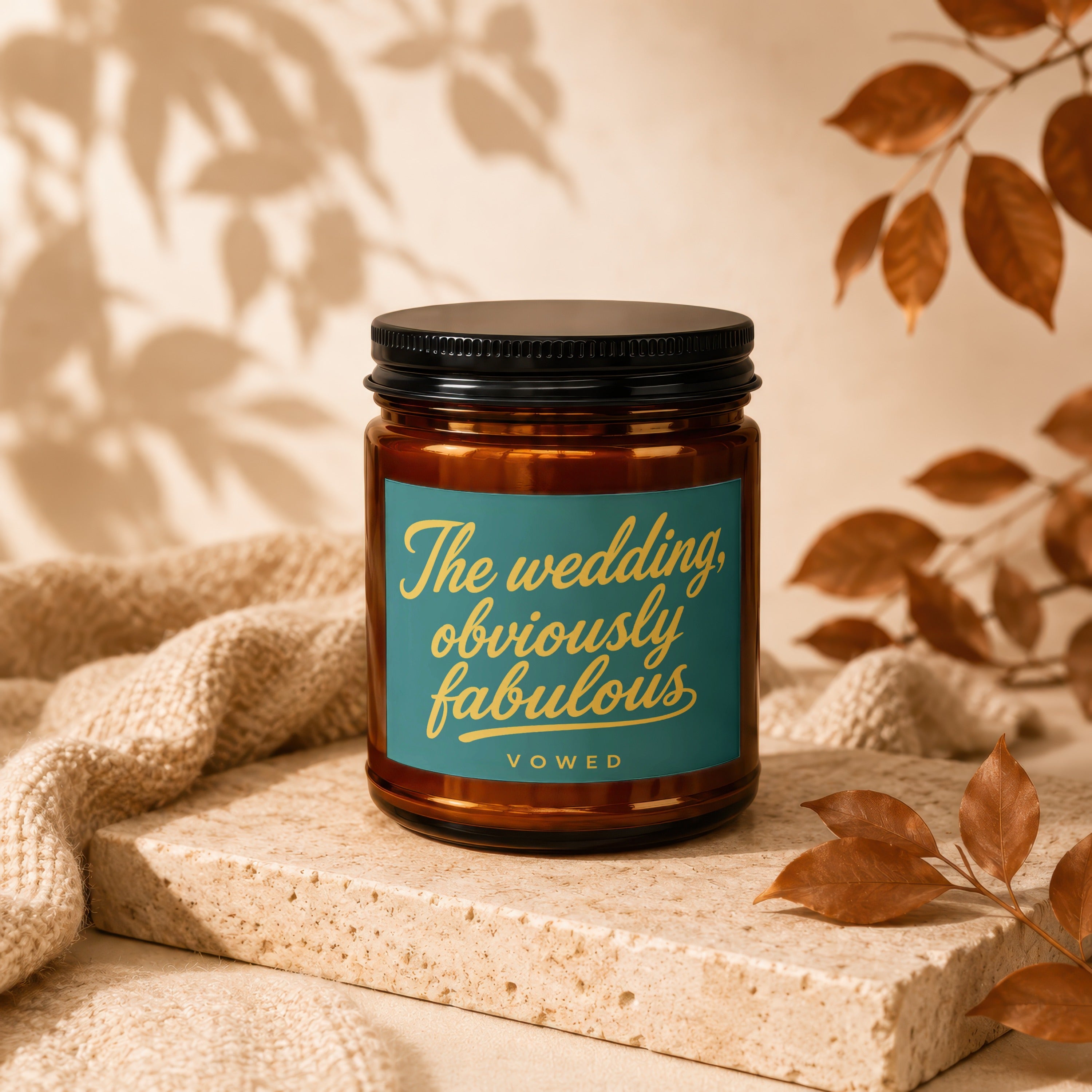 Amber candle with teal label saying "The wedding, obviously fabulous" and "vowed".