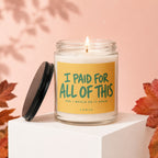 Lit candle in a jar with a yellow label saying "I PAID FOR ALL OF THIS AND I WOULD DO IT AGAIN"
