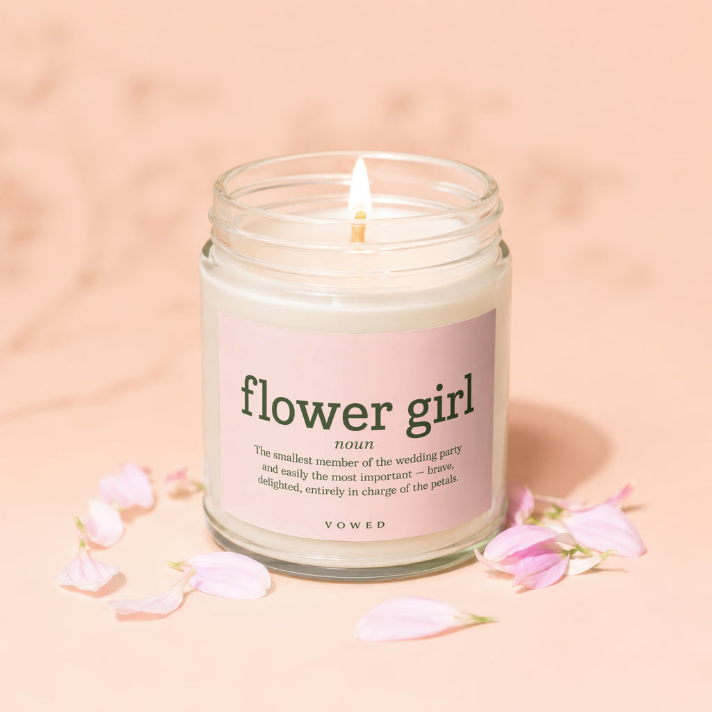 Candle from Vowed titled "flower girl" with definition and pink petals.