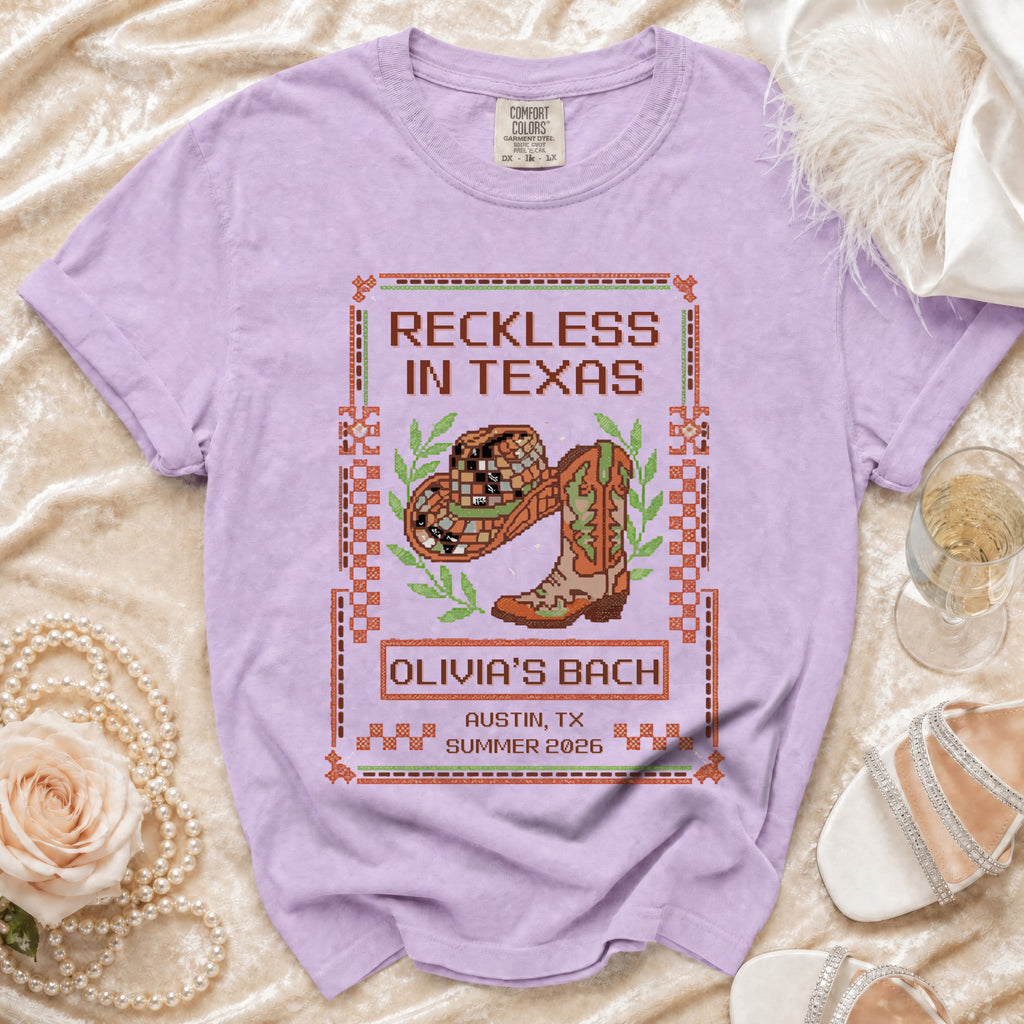 T-shirt with "Reckless in Texas" and "Olivia's Bach" text and cowboy boot graphic.