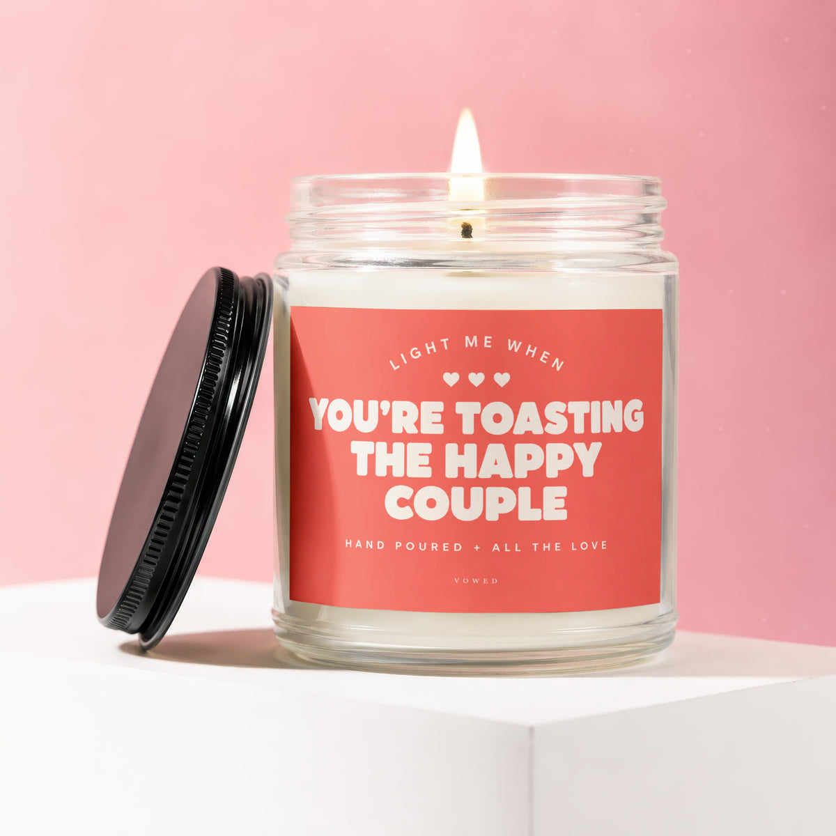 Jar candle with a coral label that reads "Light me when you're toasting the happy couple."