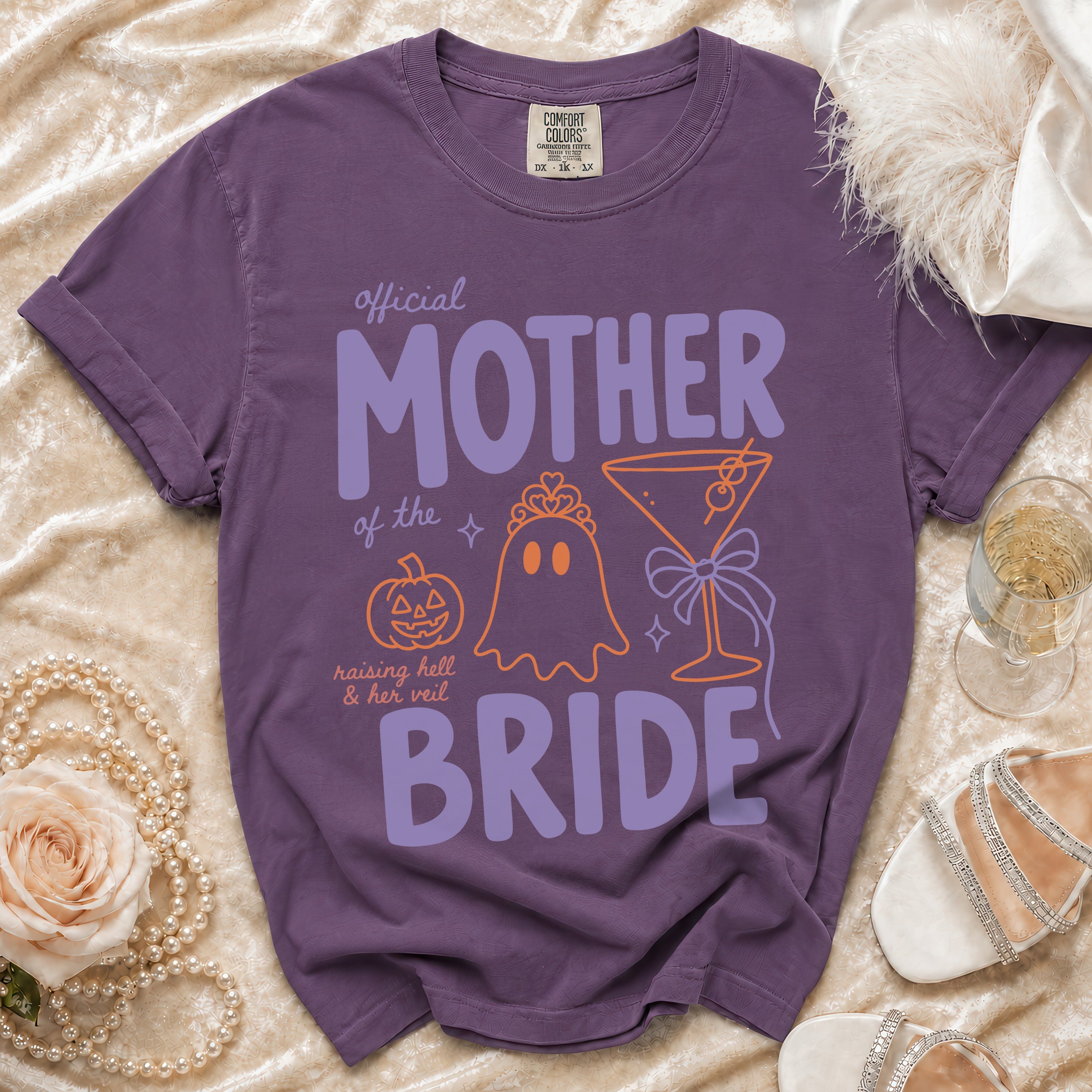 Purple Comfort Colors t-shirt with "Official Mother of the Bride" text and Halloween graphics.