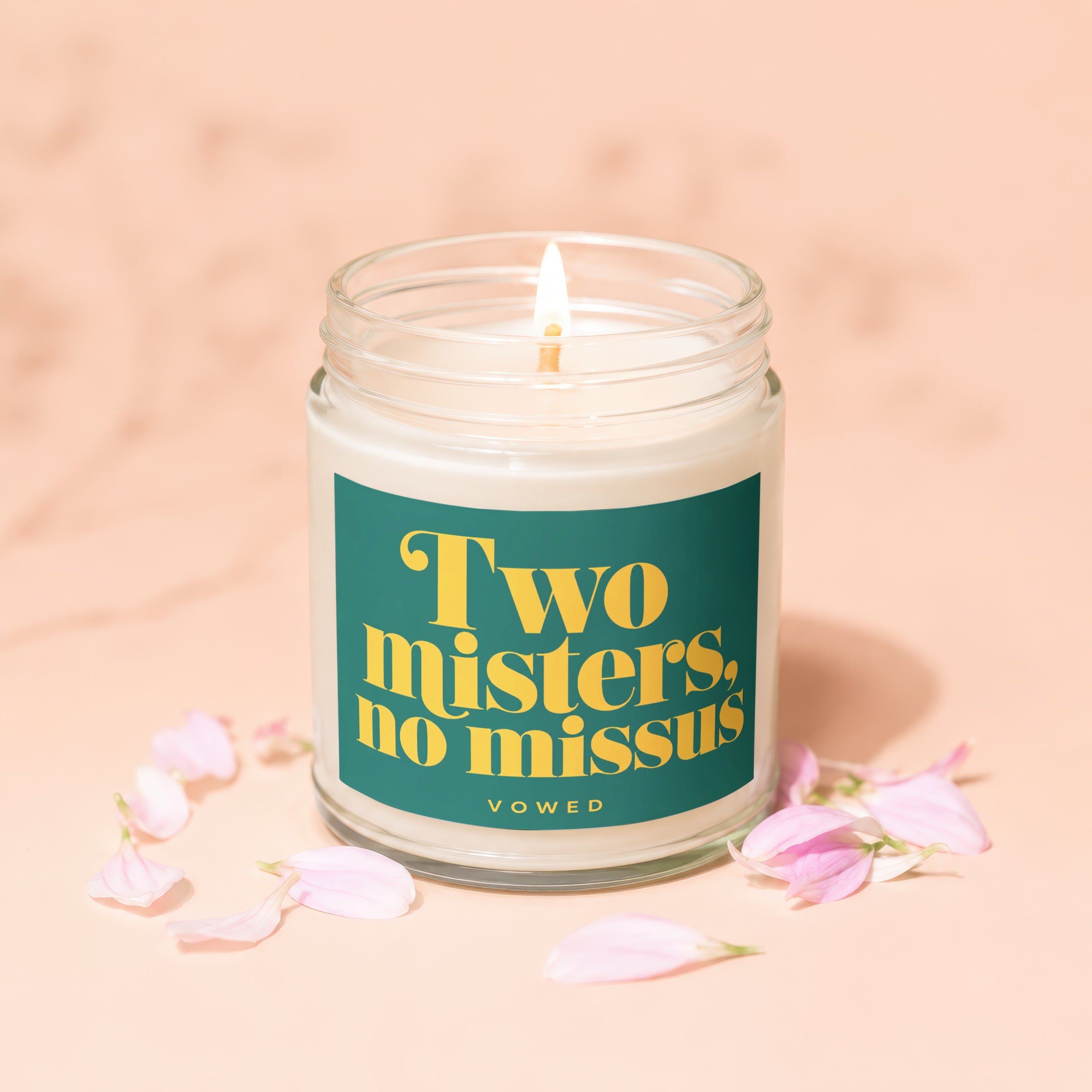 Glass jar candle with teal label reading "Two misters, no missus, vowed."