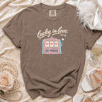 Brown t-shirt with "lucky in love" and "JUST MARRIED" text and slot machine graphic.