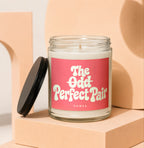 Glass candle with pink label reading "The Odd Perfect Pair" and "VOWED"