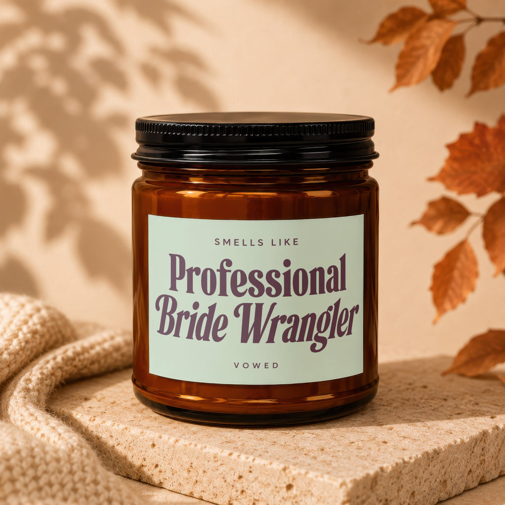 Amber jar candle with black lid labels "Smells Like Professional Bride Wrangler Vowed".
