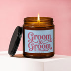 Amber jar candle with lit wick and text "Groom x Groom VOWED"