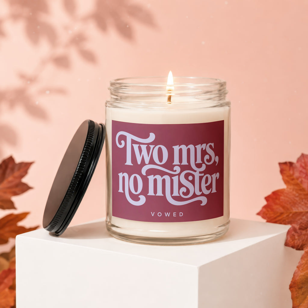 Glass candle on white cube with dark lid, reads "Two mrs, no mister."