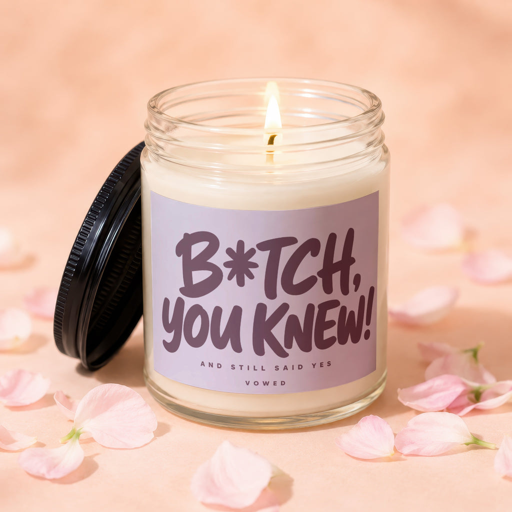 Glass candle with lit wick and a label that reads "B*TCH, YOU KNEW! AND STILL SAID YES".