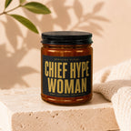 Amber candle in glass jar with black lid and "Chief Hype Woman" label.