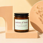 Brown glass candle with a label that reads "matron of honor" and a quote about brides.