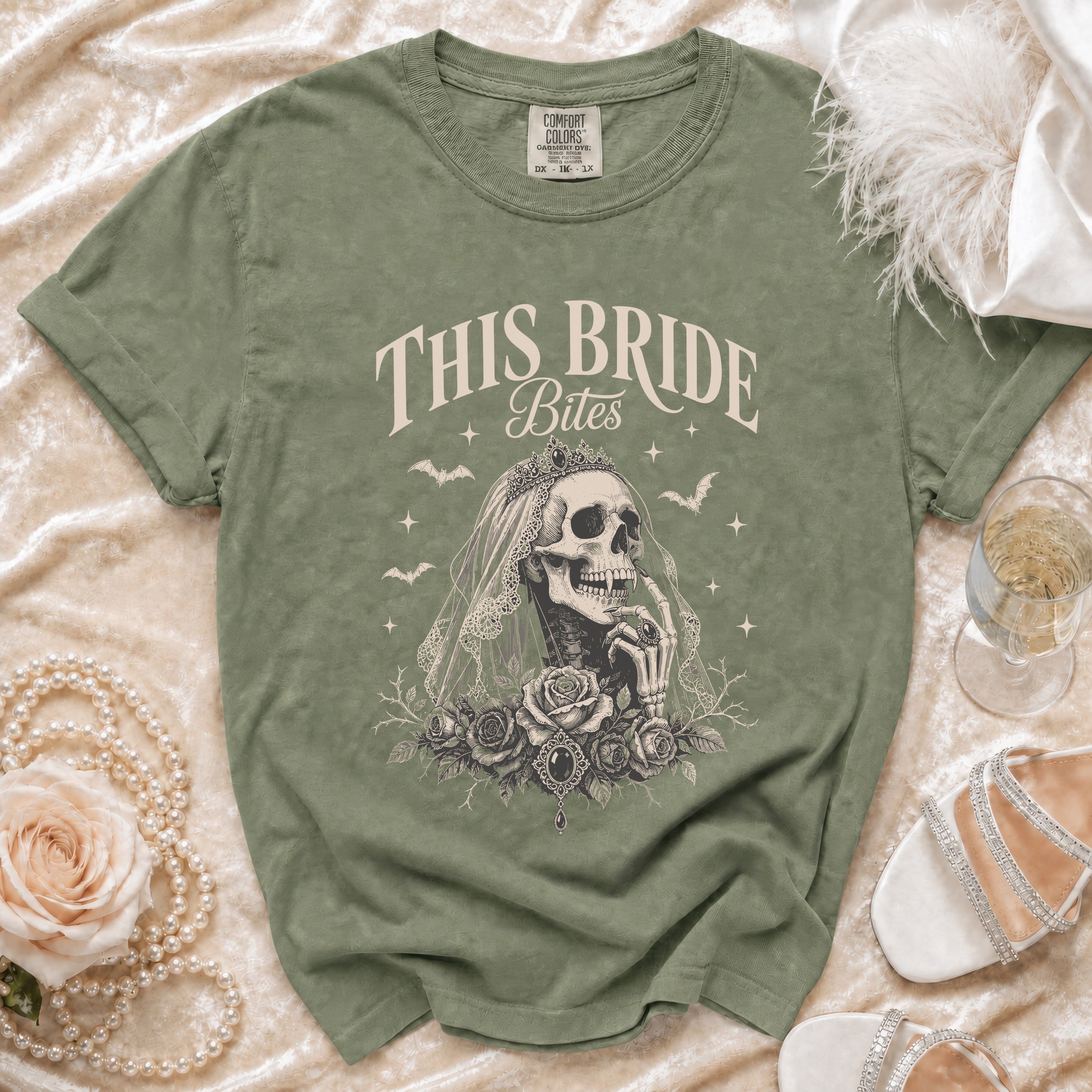 Olive green t-shirt with "This Bride Bites" skeleton bride graphic.