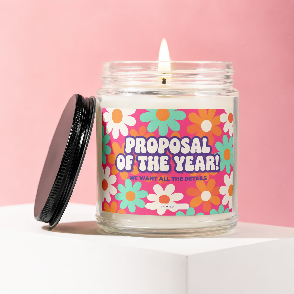 Candle with floral label saying "Proposal of the Year! We Want All the Details."