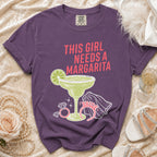 Purple t-shirt with "This Girl Needs A Margarita" and margarita graphic.