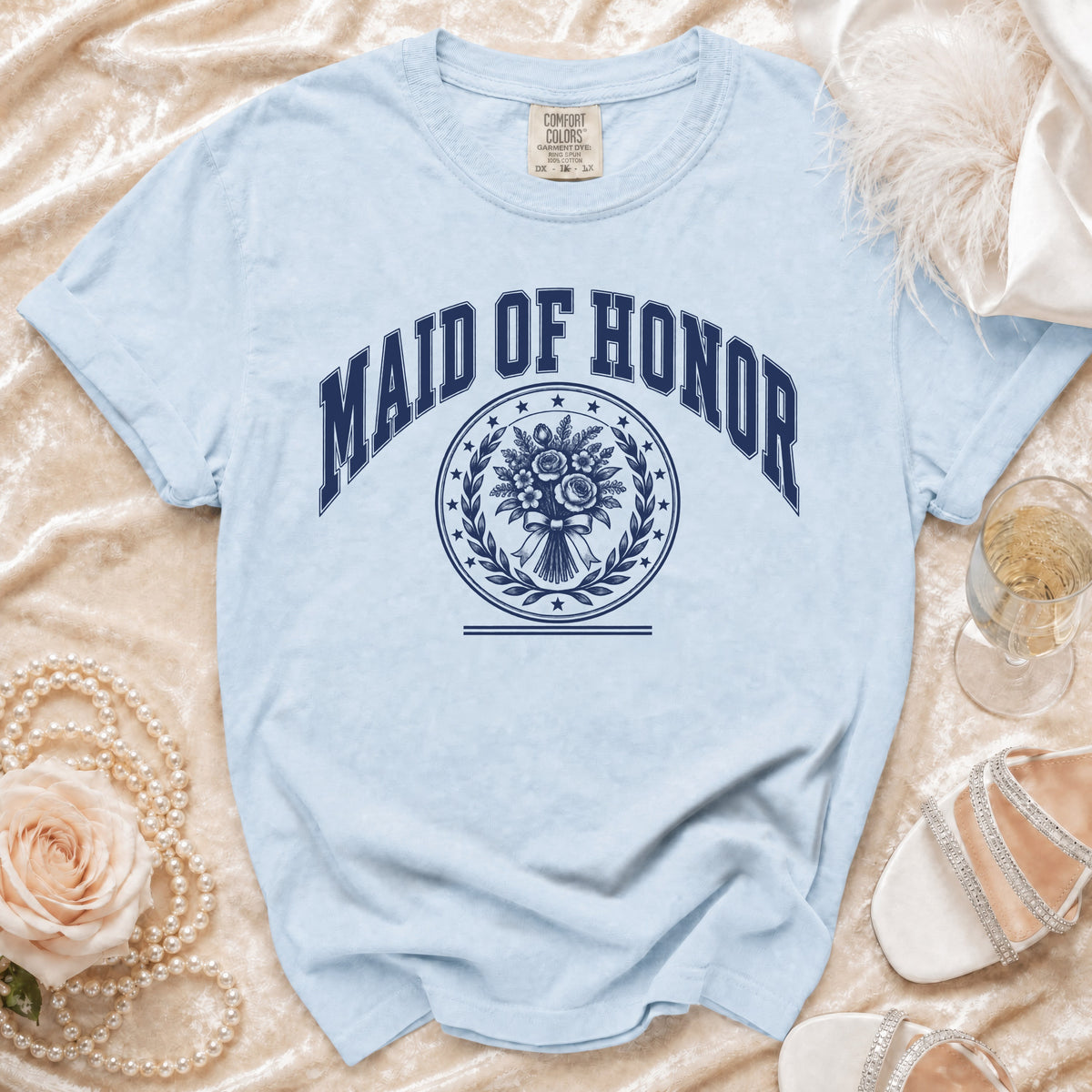 Light blue t-shirt with "MAID OF HONOR" text and floral wreath design.