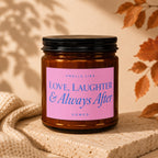 Amber jar candle with pink label reading "Love, Laughter & Always After".