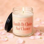 Candle with a lit wick and a black lid, text says "Smells Like Family By Choice, Not Chance."