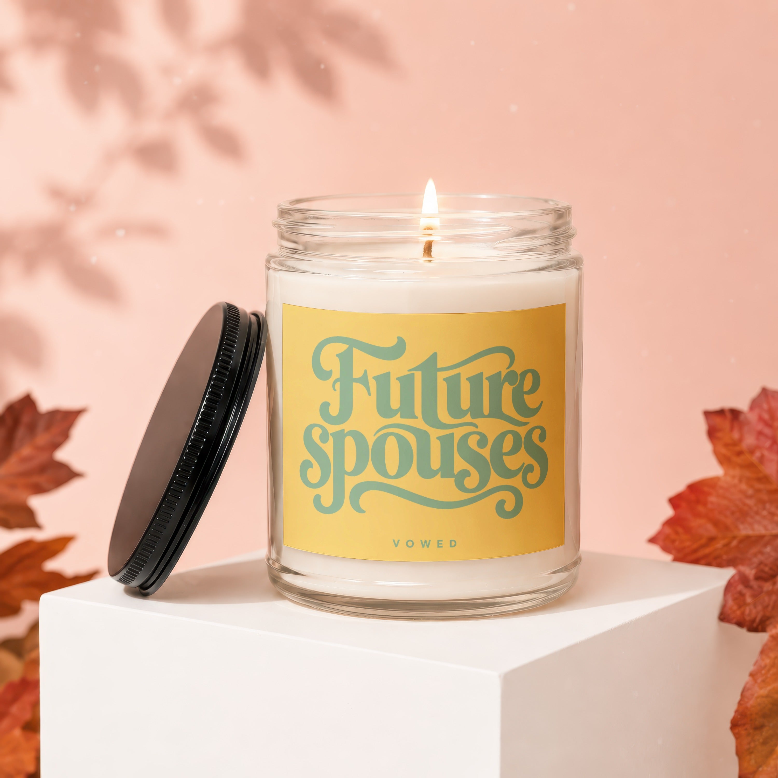 Candle with "Future spouses" text and a lid nearby, surrounded by autumn leaves.
