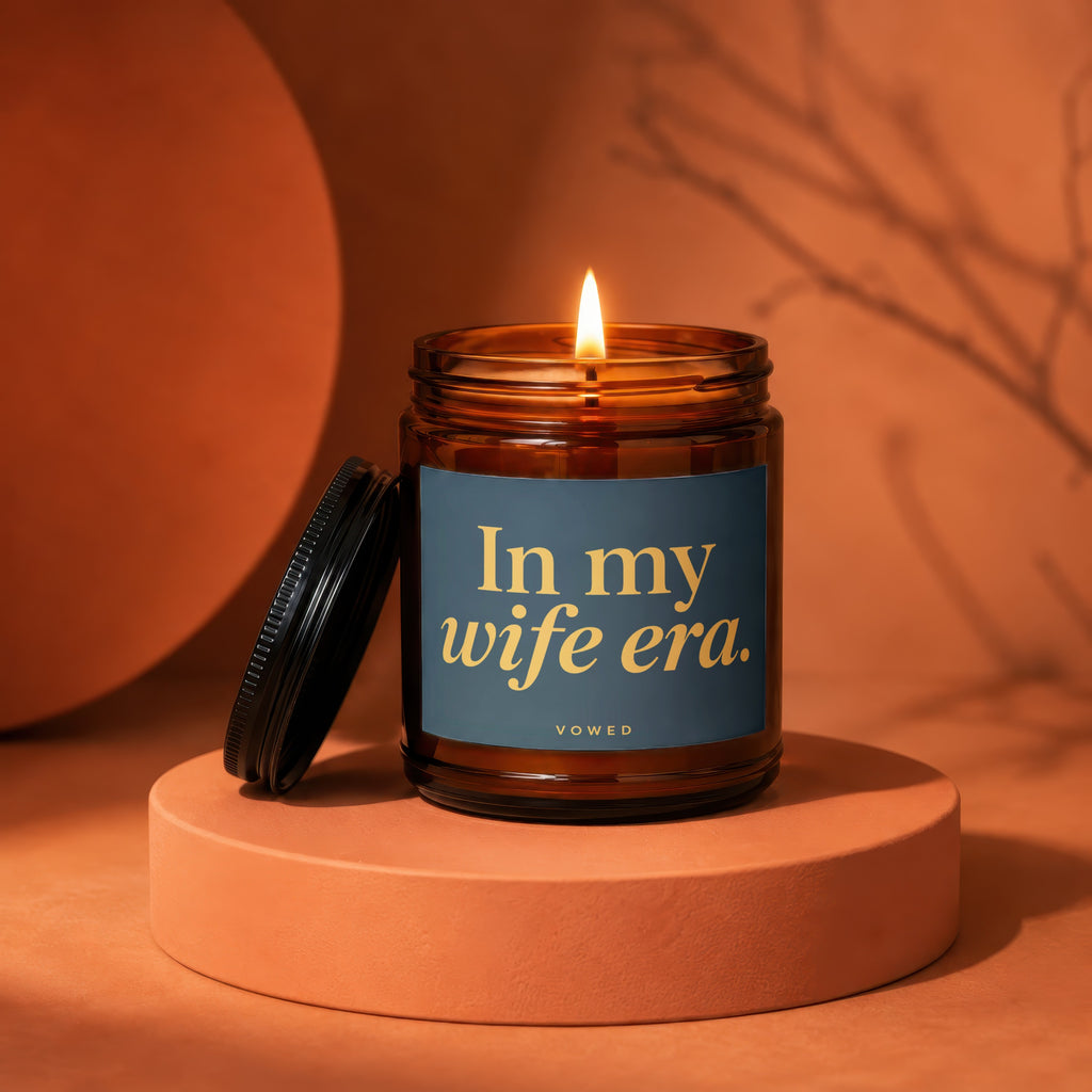 Lit amber jar candle with label reading "In my wife era."