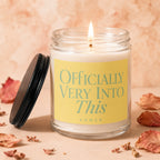 Glass candle with yellow label reading "Officially Very Into This".