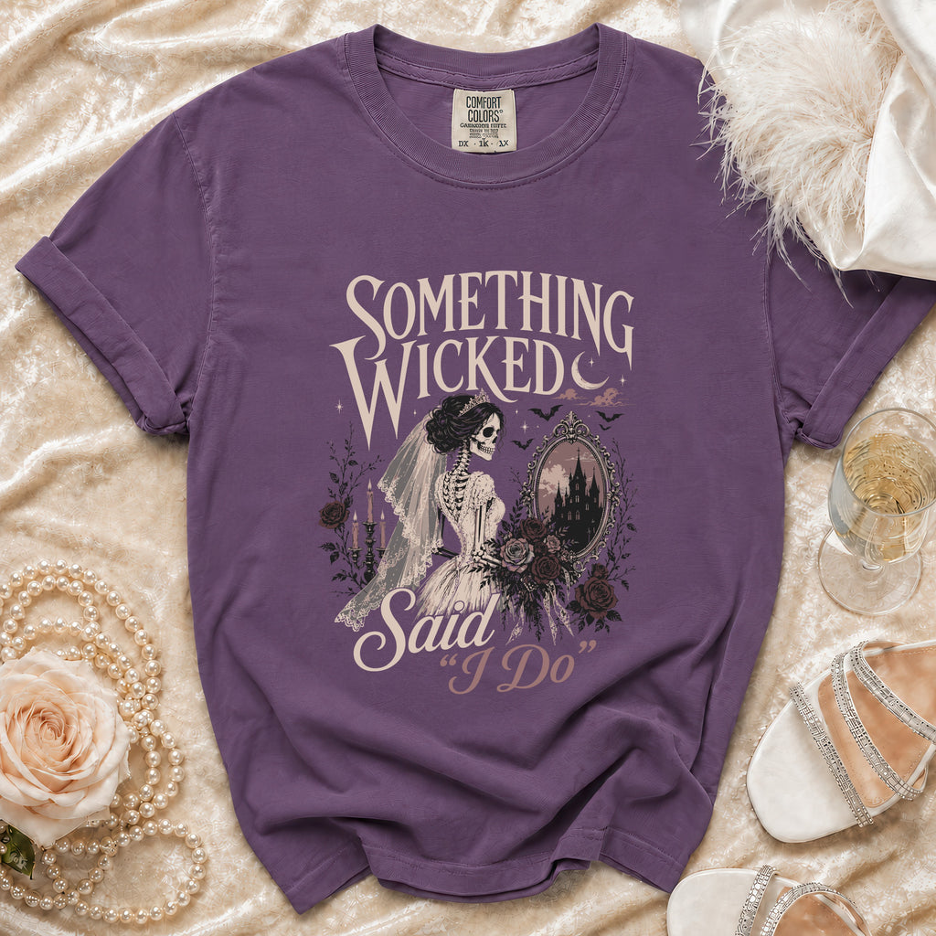 Purple t-shirt with skeleton bride graphic reading "Something Wicked Said 'I Do'".