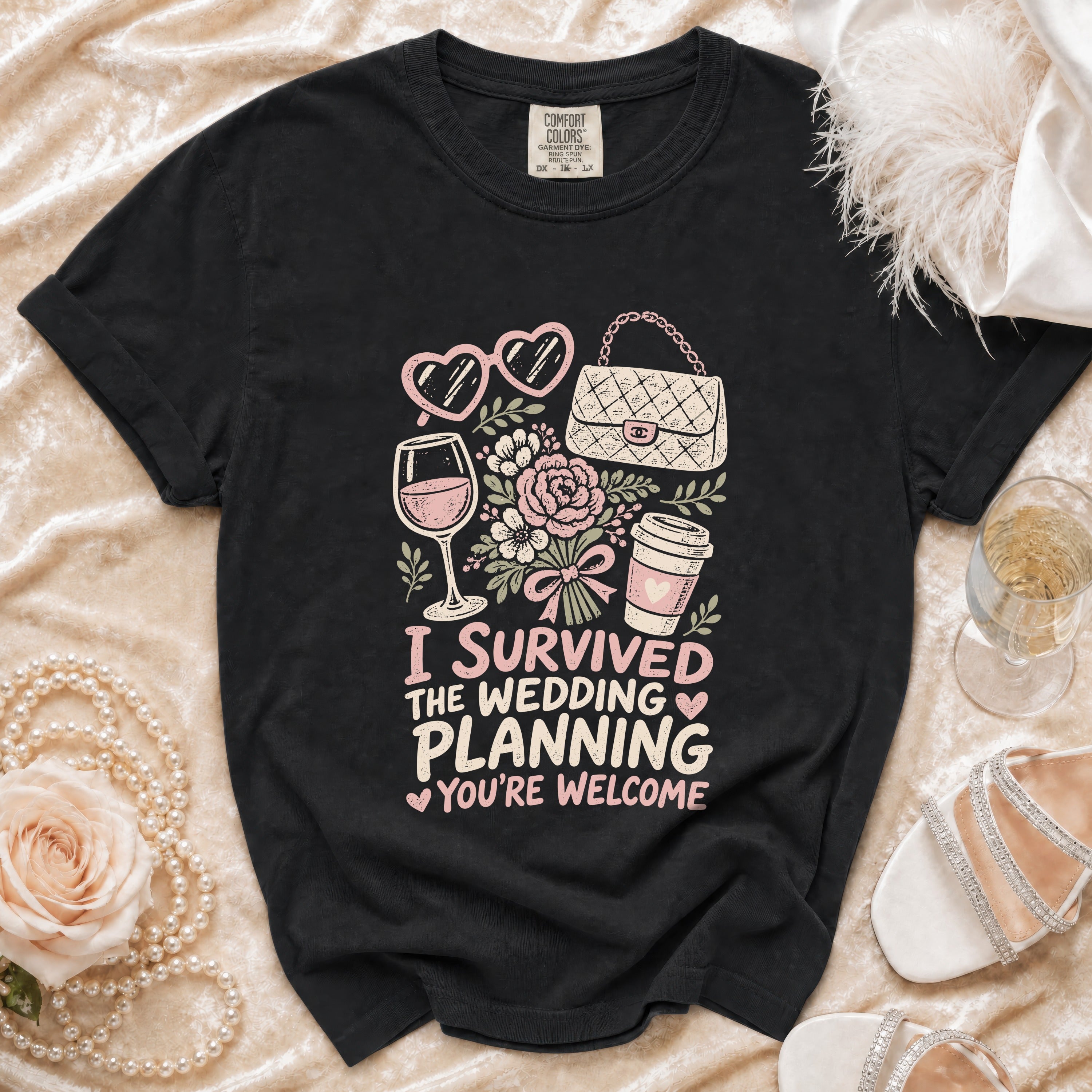 Black t-shirt with "I survived the wedding planning you're welcome" graphic.