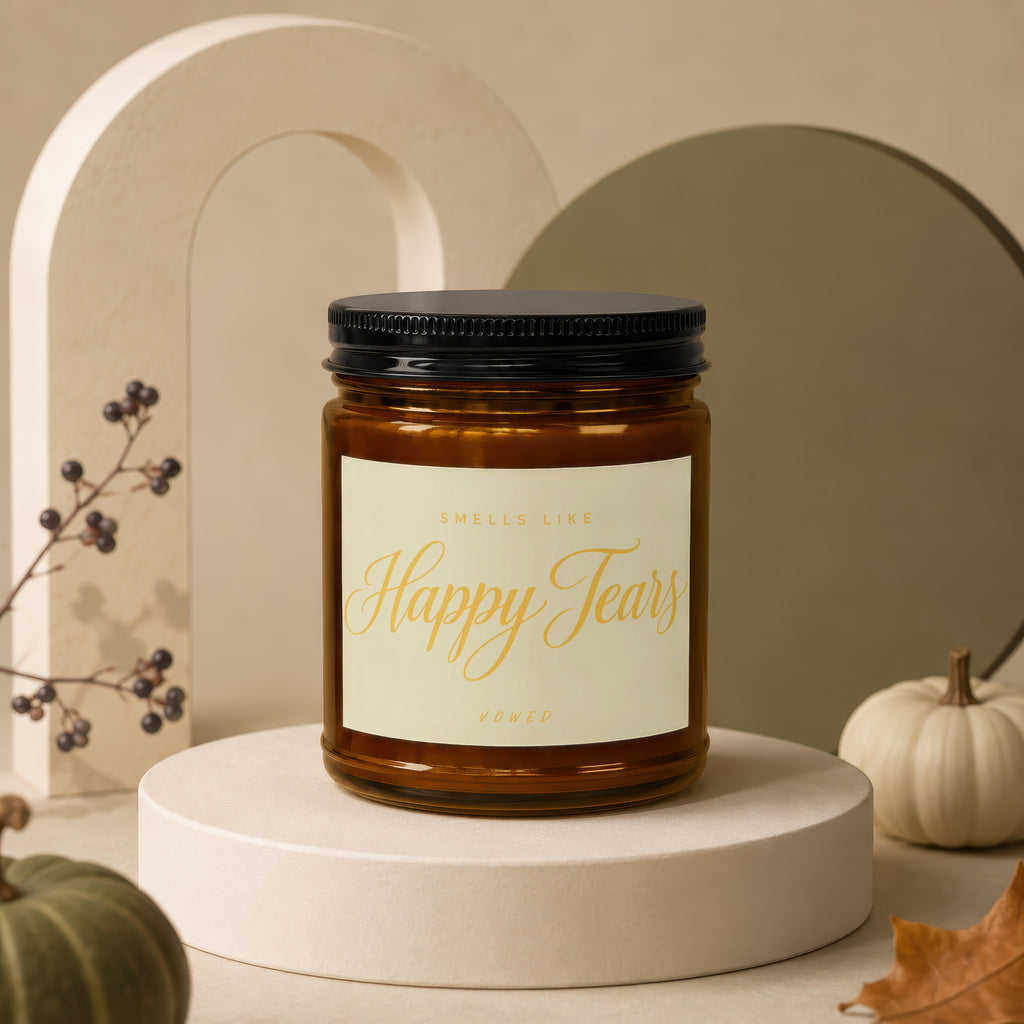 Amber jar candle with label reading "Smells Like Happy Tears Vowed".