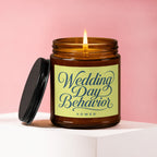 Amber candle with lit flame, lid off, and label reading "Wedding Day Behavior VOWED".