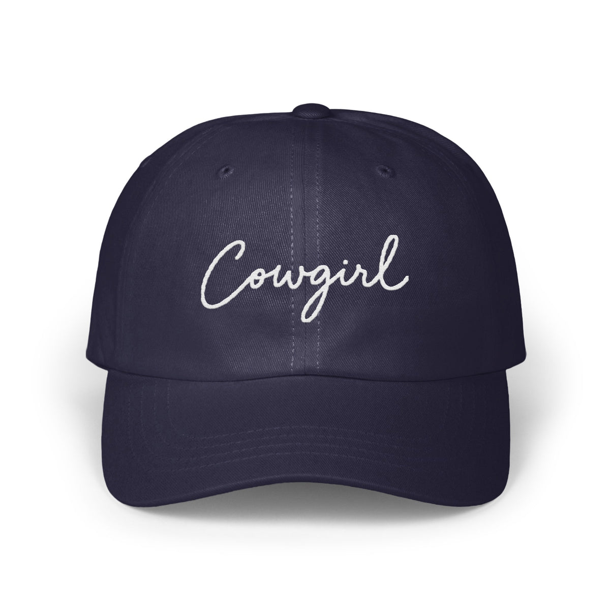 A dark navy blue baseball cap with the word Cowgirl embroidered in white script across the front.