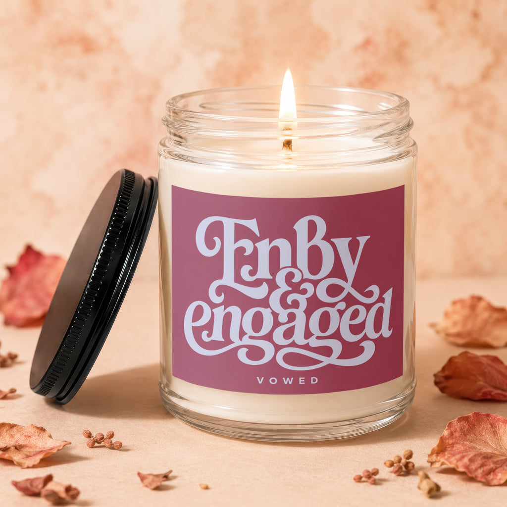Lit candle in a glass jar with "Fnbdy engaged" text on a pink label.