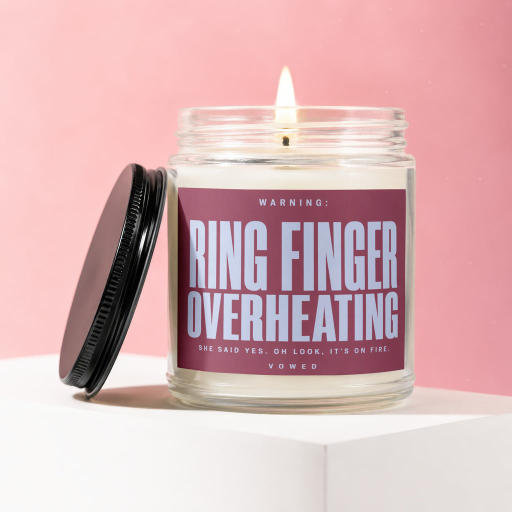 Jar candle with "Ring Finger Overheating" warning and "She Said Yes" text.
