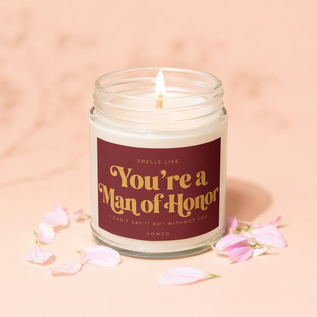 Scented candle with "You're a Man of Honor" text, surrounded by petals.