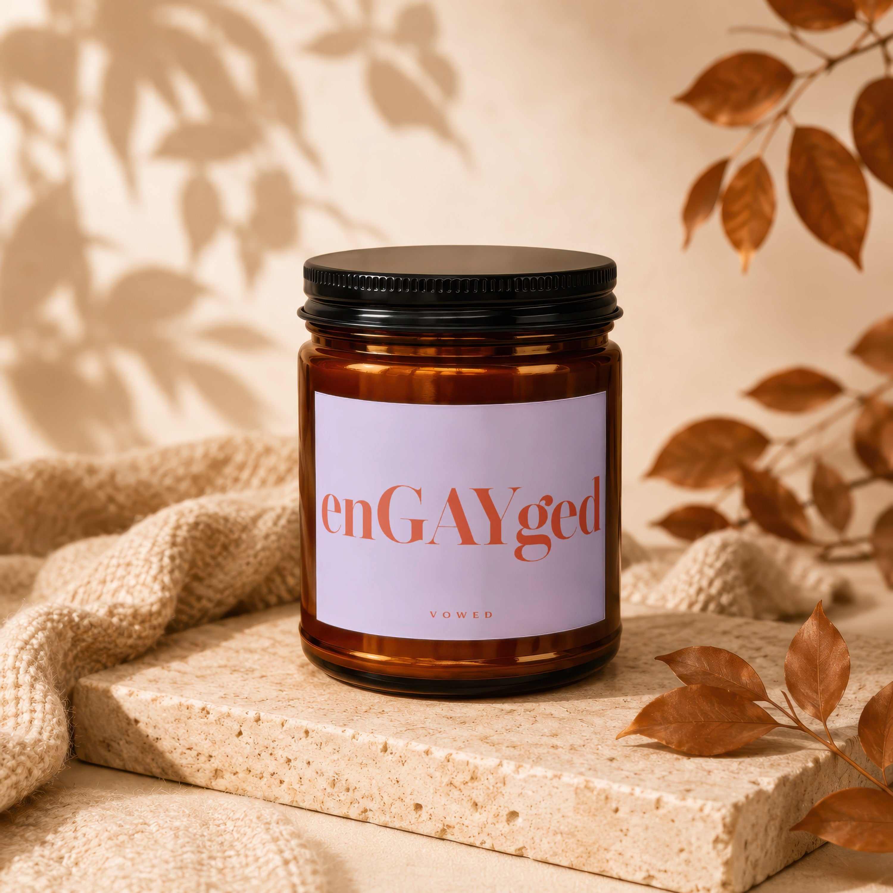 Amber glass candle with "enGAYged" and "VOWED" on label.