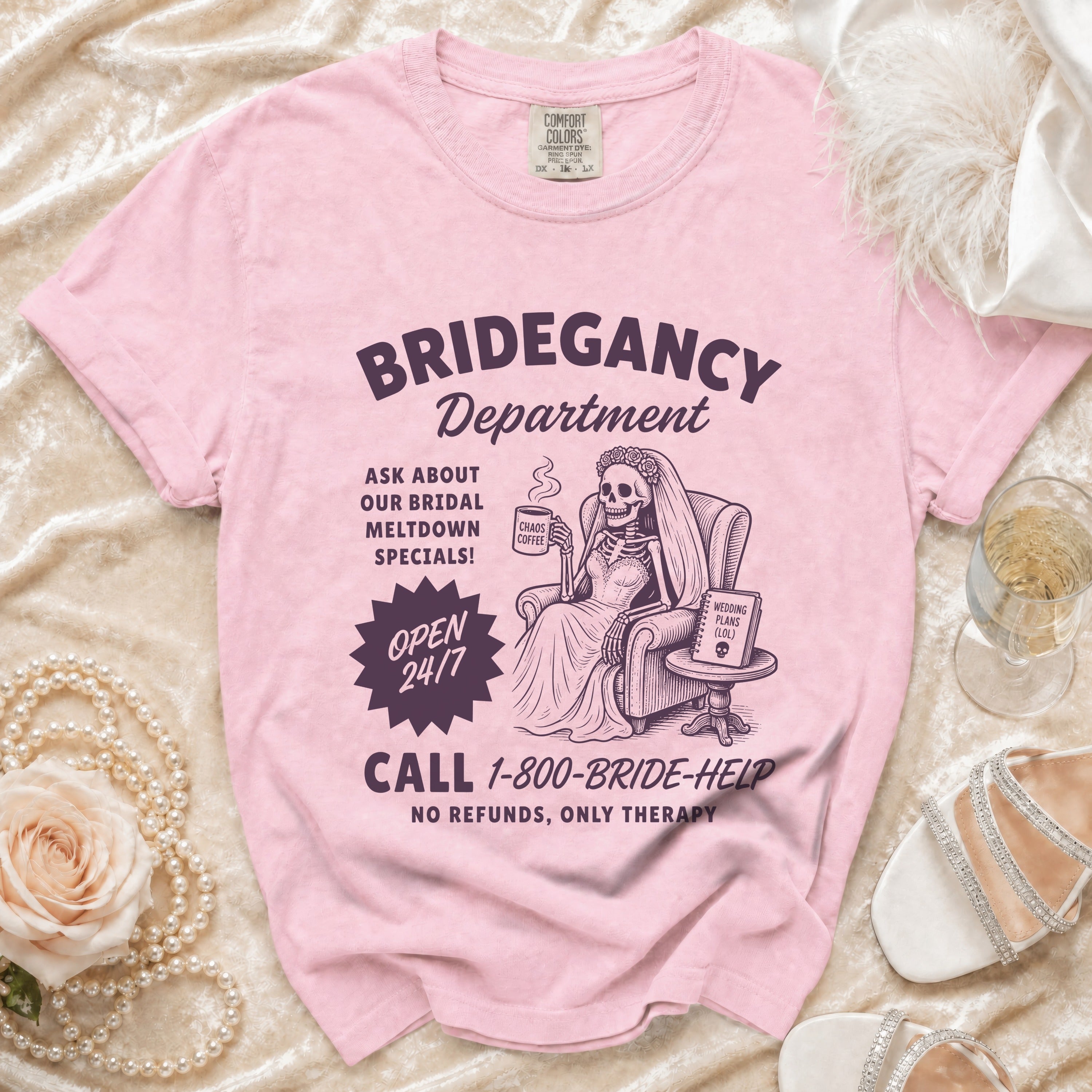 Pink t-shirt with skeleton bride graphic: "Bridegancy Department", "Open 24/7", "Call 1-800-BRIDE-HELP".