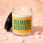 A lit candle in a jar with a yellow label reading "Diamond Acquired" and "Vowed".