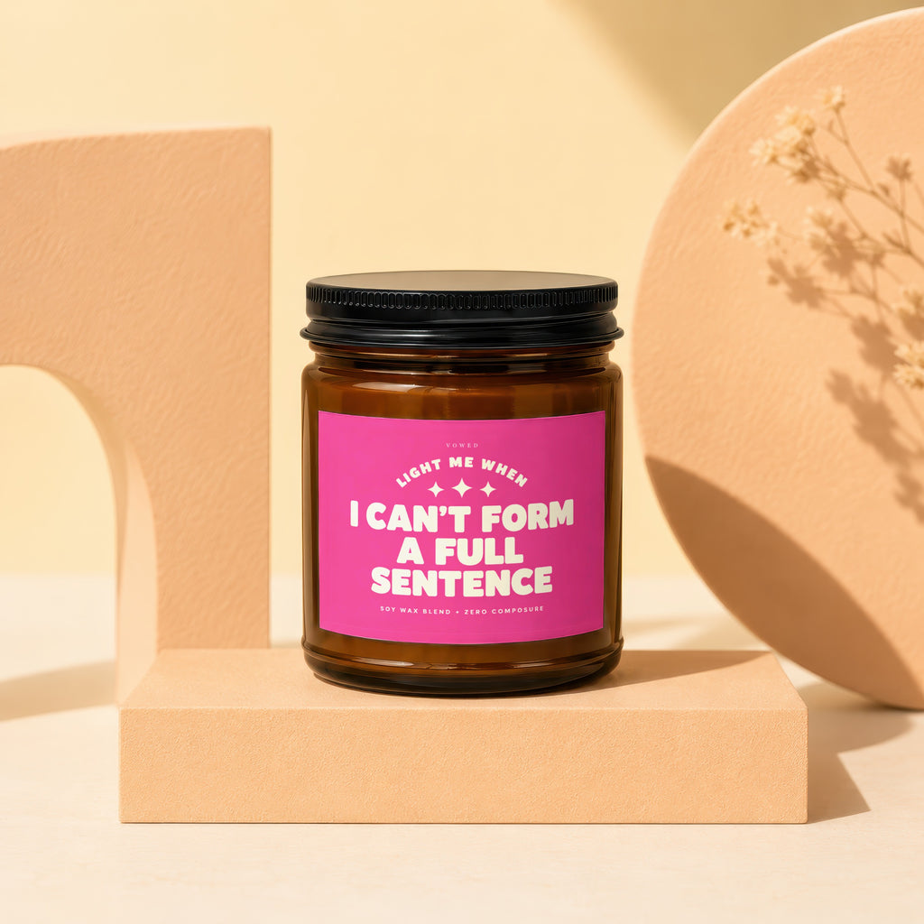 Amber jar candle with pink label that reads "Light me when I can't form a full sentence".
