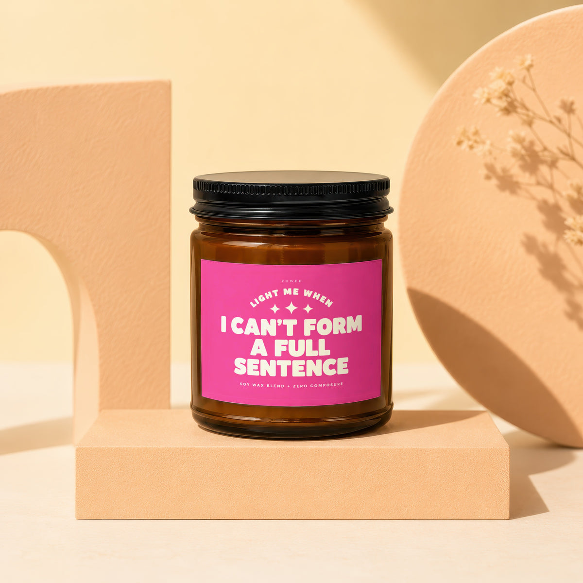 Amber jar candle with pink label that reads "Light me when I can't form a full sentence".