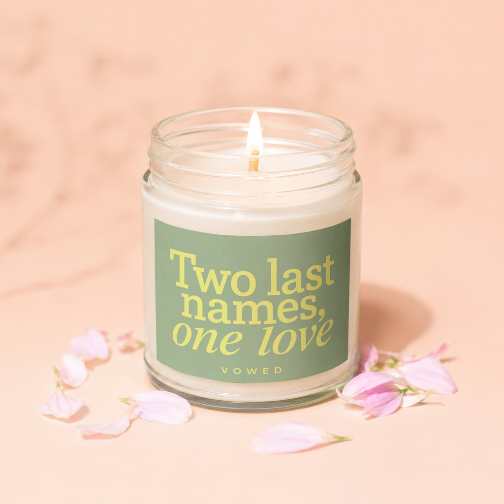 Jar candle with label "Two last names, one love" surrounded by pink petals.