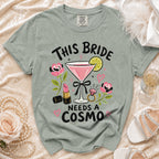 Shirt with "This Bride Needs a Cosmo" text, martini glass, lipstick, and ring.