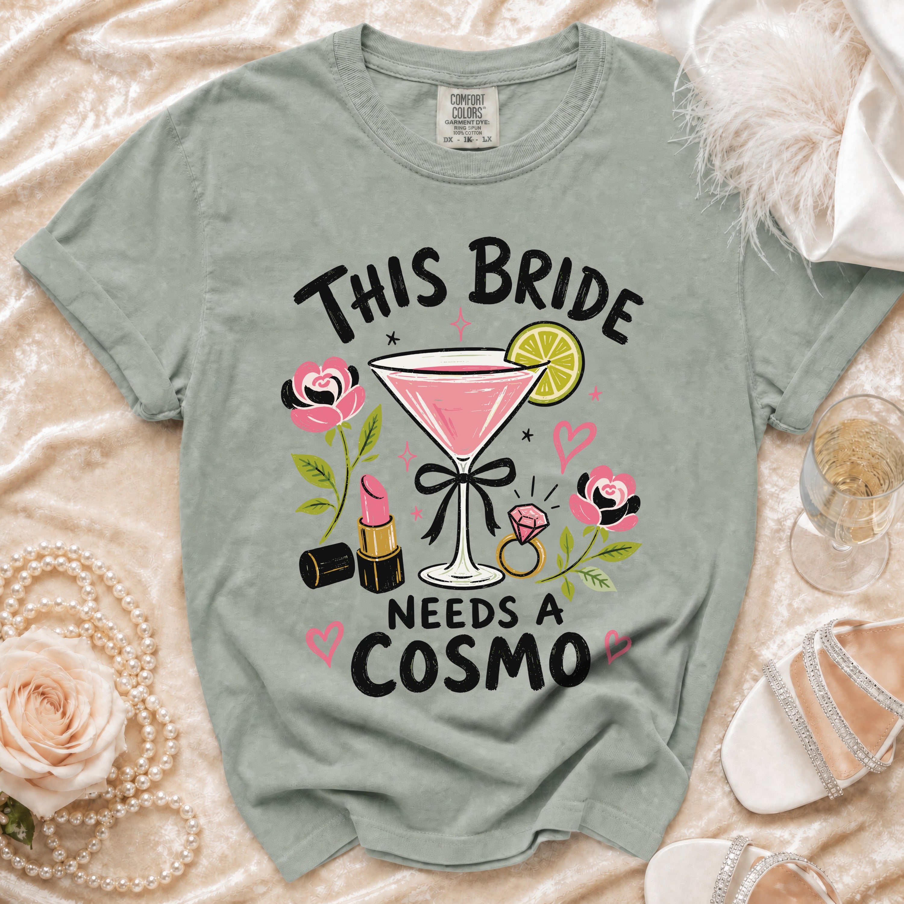 Shirt with "This Bride Needs a Cosmo" text, martini glass, lipstick, and ring.