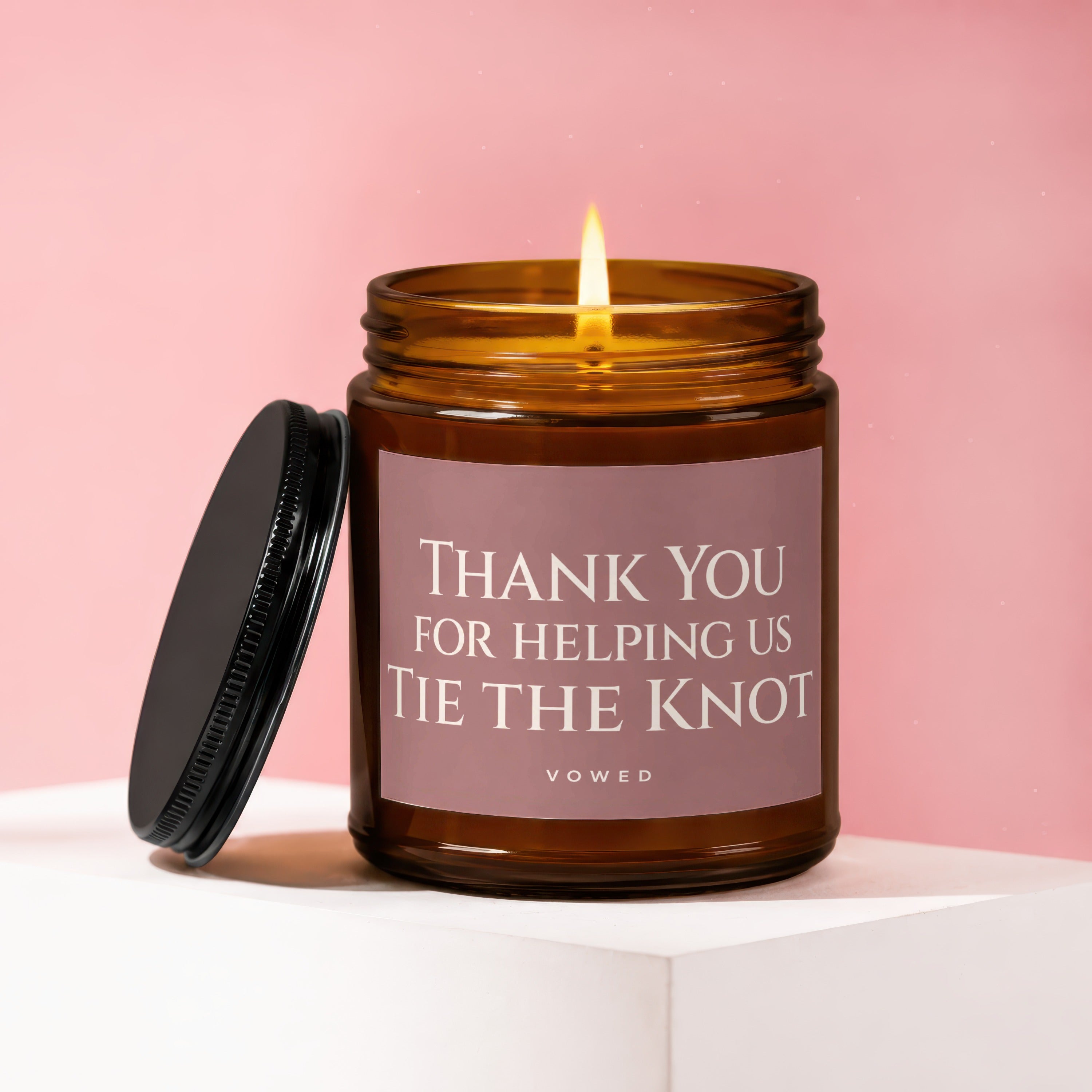 Thank You For Helping Us Tie The Knot candle with lit flame.