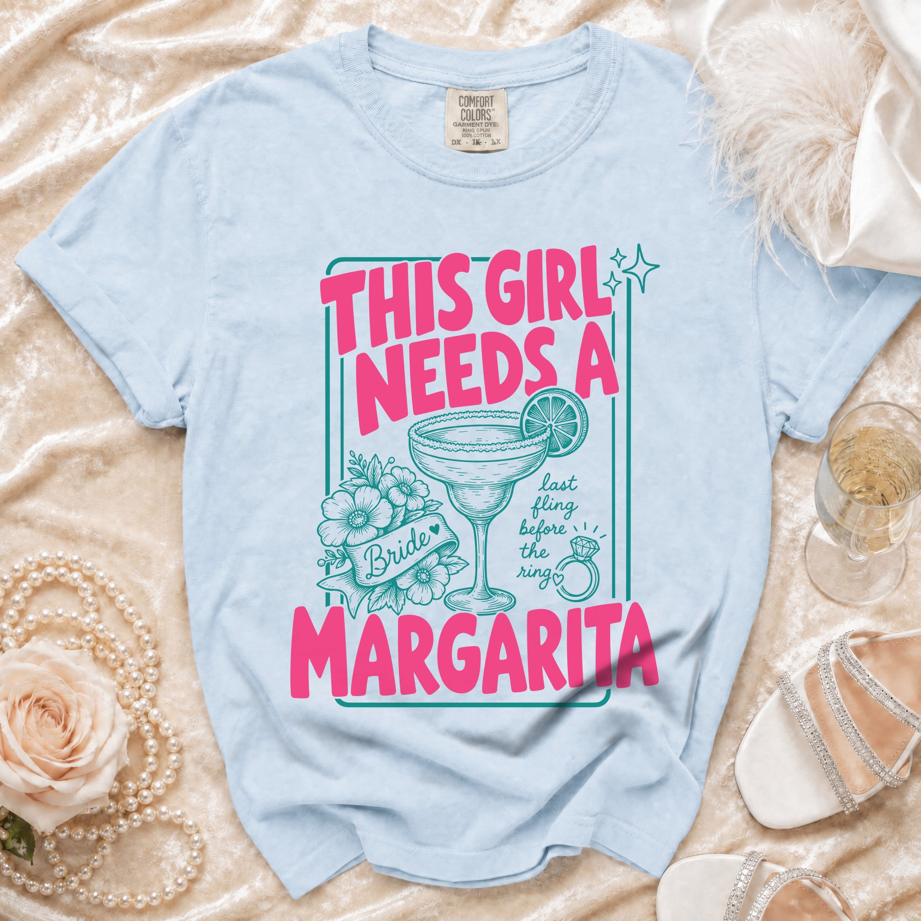 Light blue Comfort Colors t-shirt with "This girl needs a margarita" graphic.