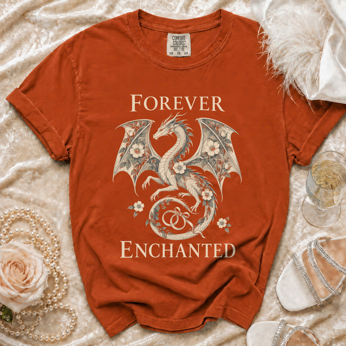 Orange t-shirt with dragon and floral design reading "Forever Enchanted."