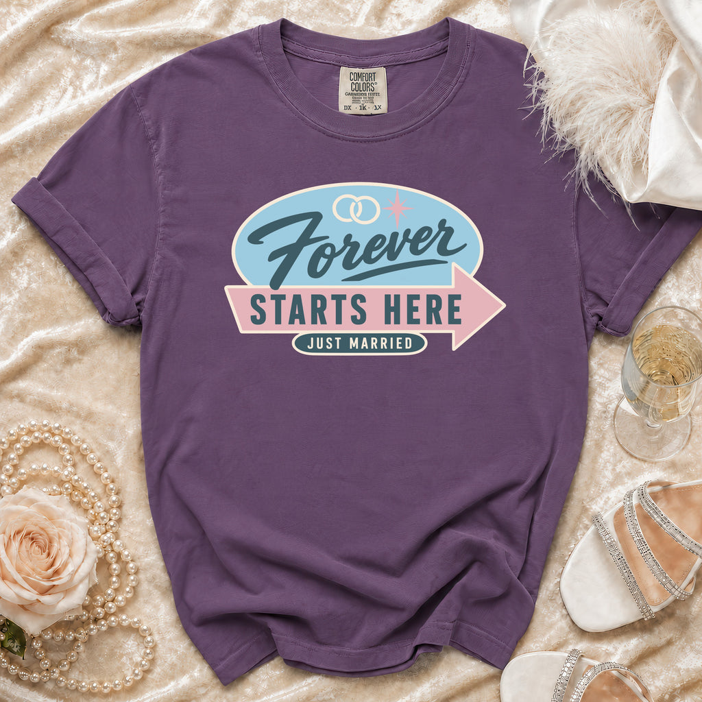 Purple t-shirt with "Forever Starts Here Just Married" graphic and wedding rings.