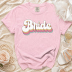 Pink t-shirt with layered rainbow bubble text spelling "Bride".