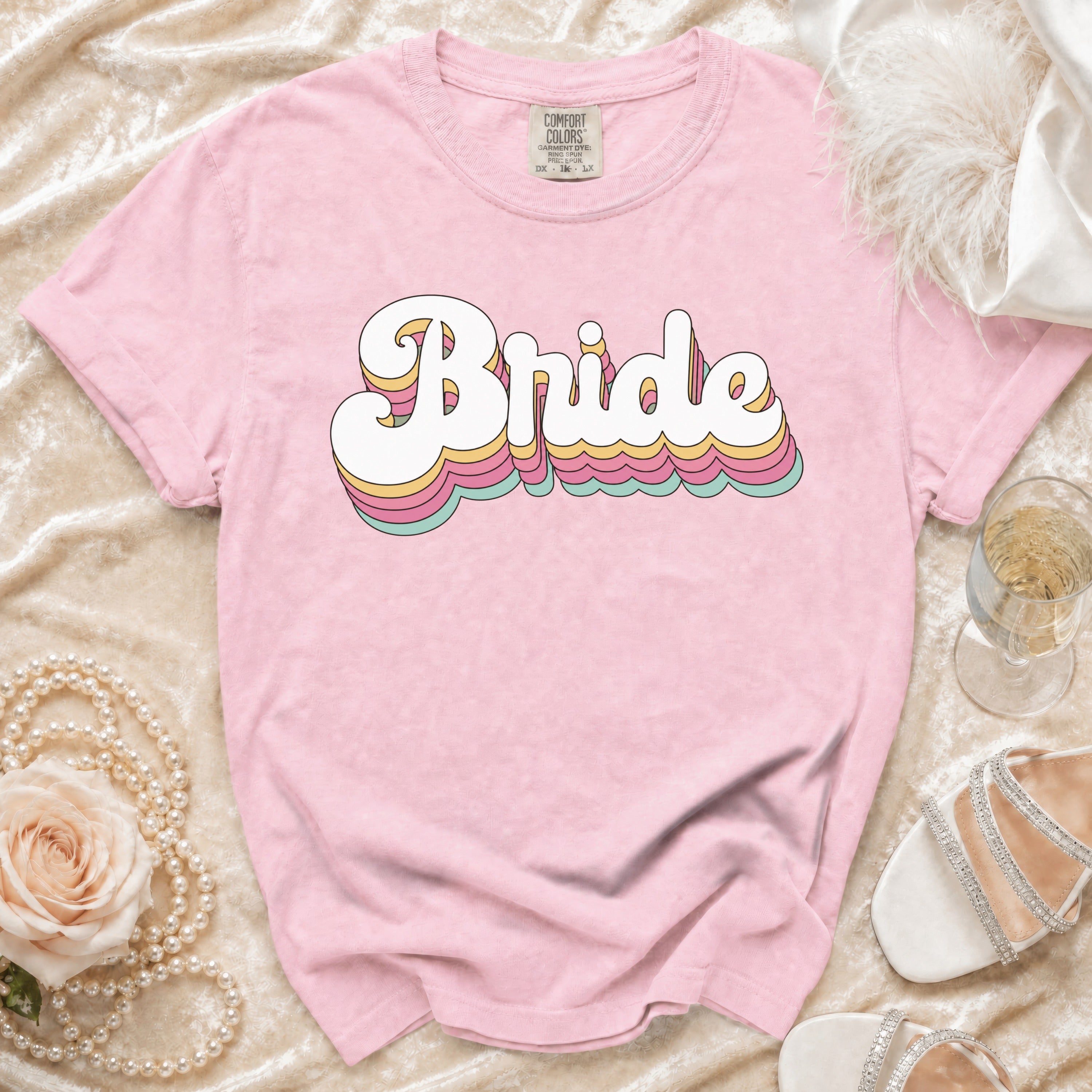 Pink t-shirt with layered rainbow bubble text spelling "Bride".
