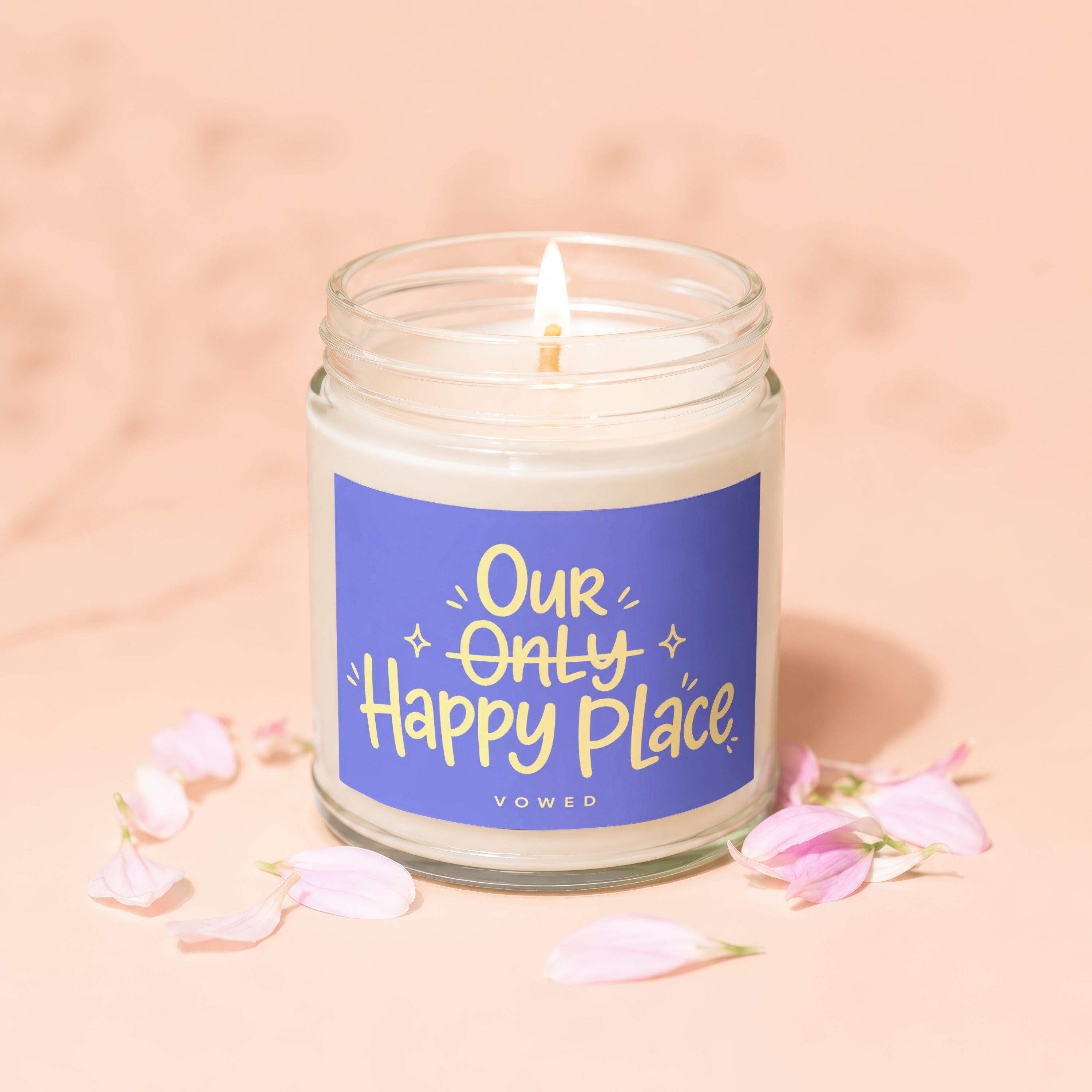 Glass jar candle with blue label reading "Our Only Happy Place VOWED".